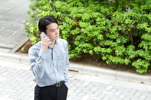 外で電話する男性
