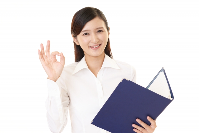 okサインをしてファイルを片手にもつ女性