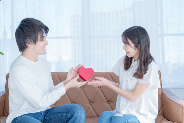 ハートの小物をお互い両手で支え微笑みあうカップル