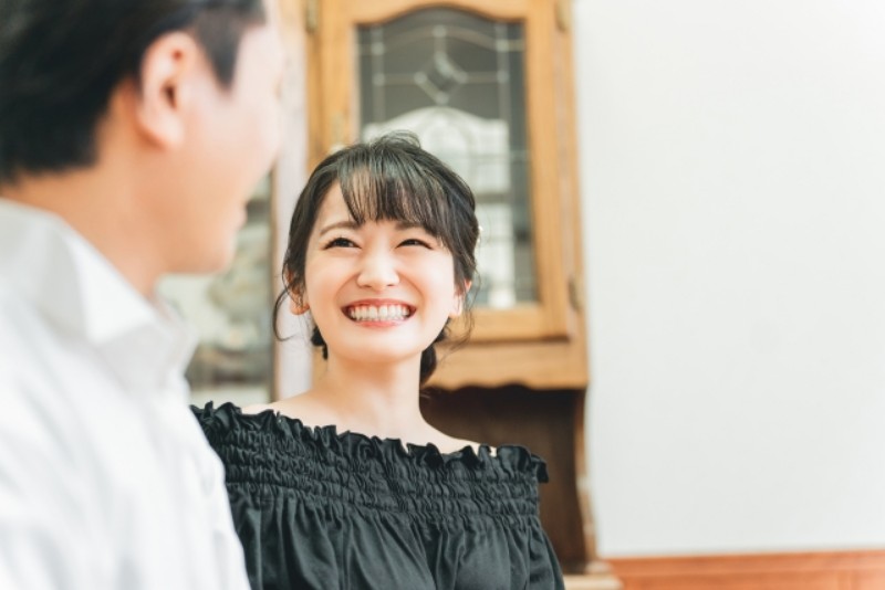 結婚相談所で黒い服を着て男性と微笑みあう女性